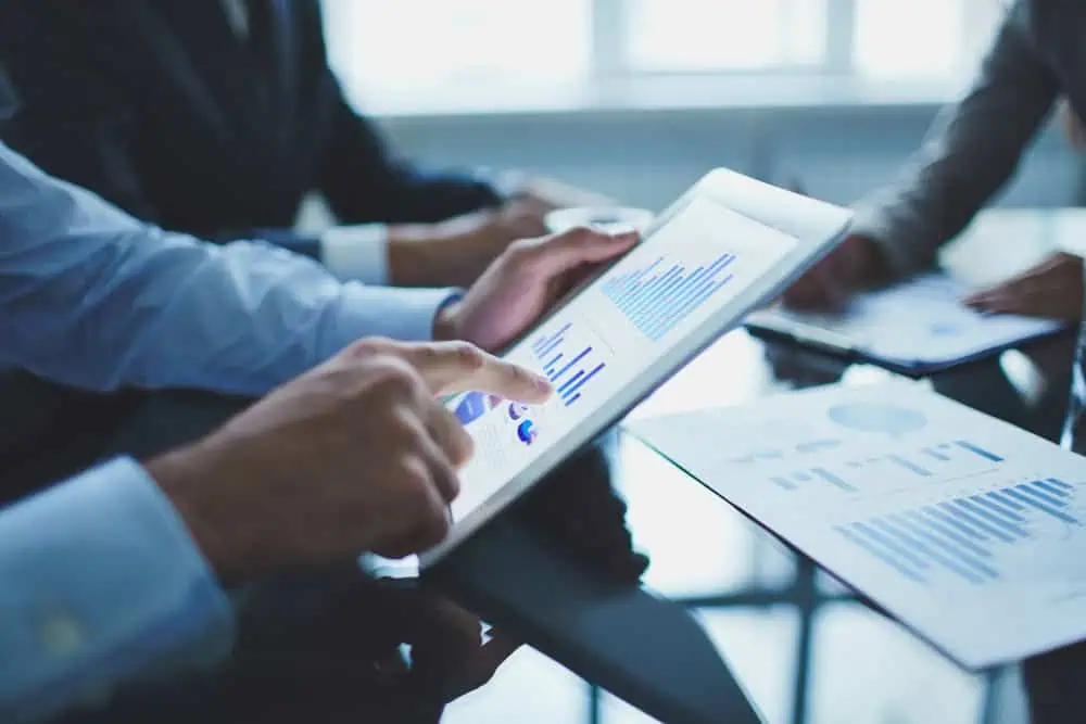 Modern FP&A professional presenting performance—holding a report and pointing to graphs for a stakeholder.